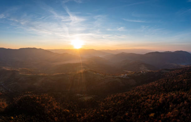 istock Forest on mountain ridge under cloudy sky at bright sunset 1365173836