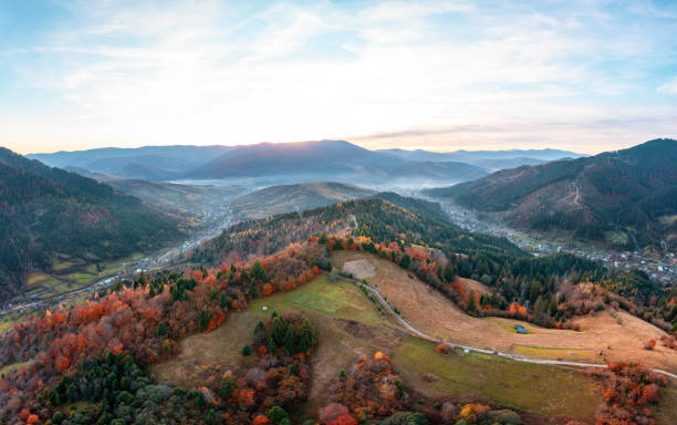 istock Mountain peaks covered with colorful trees at sunset 1365175472