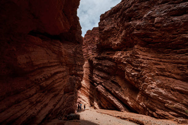 туристы совершают поездку по образованию амфитеатр в природном заповеднике кебрада-д�е-лас-кончас в жаркий полдень - cave canyon rock eroded стоковые фото и изображения
