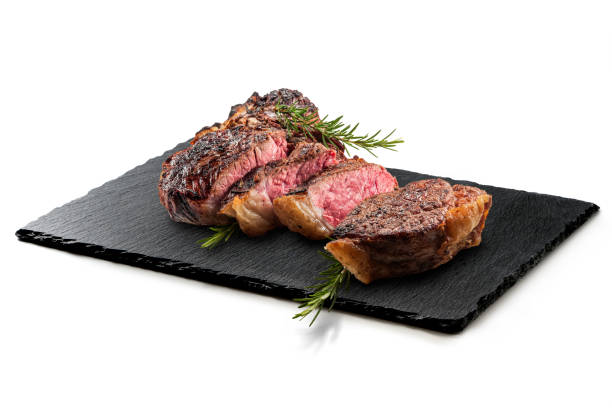 Fiorentina T-bone steak on Rectangular plate in black slate Fiorentina T-bone steak on Rectangular plate in black slate isolated on white background porterhouse steak stock pictures, royalty-free photos & images