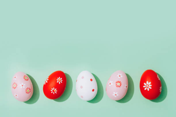 easter greeting card - red and pink easter eggs on pastel mint background with copy space for text. flat lay, selective focus - easter eggs red imagens e fotografias de stock