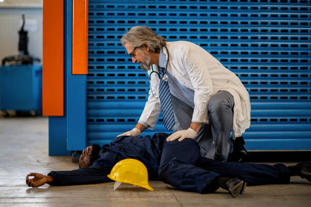 istock Doctor examining unconscious worker lying on a floor 1365183438