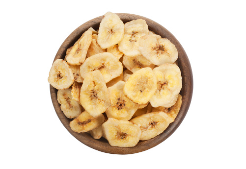 Studio shot of banana chips in a wooden bowl cut out against a white background