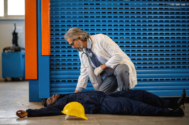 istock Doctor examining unconscious worker lying on a floor 1365187063