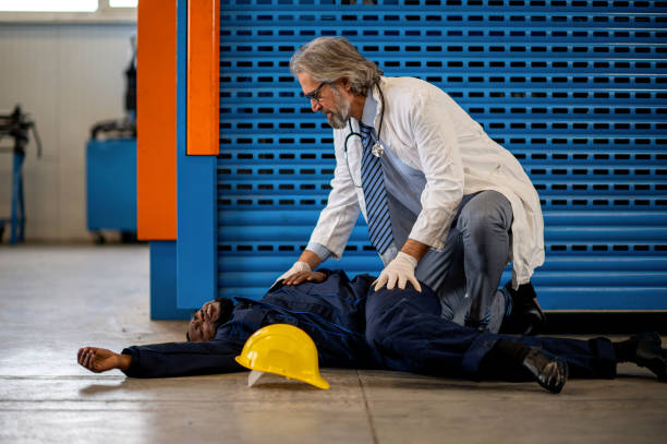 istock Doctor examining unconscious worker lying on a floor 1365187173