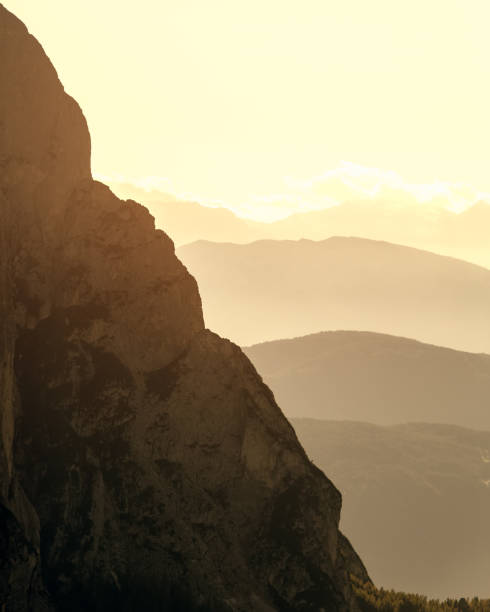 朝のヘイズでプンタ・ユーリンガー山とヴァル・ガーデナ山脈の斜面(縦線写真) - mountain valley european alps shade ストックフォトと画像