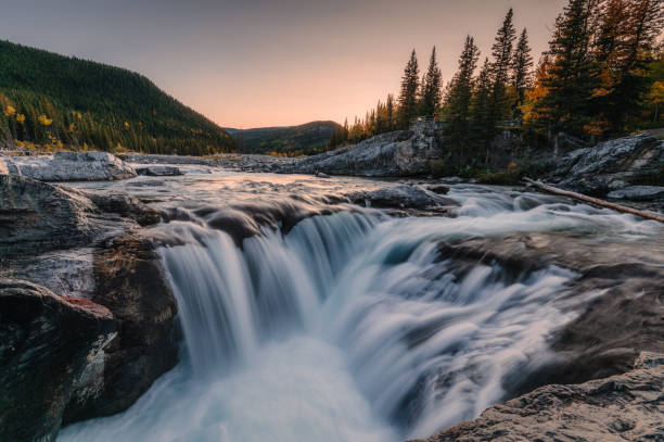 istock Elbow falls waterfall rapids flowing on rocks in autumn forest at national park 1365187313