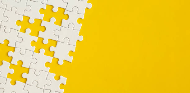 istock White details of puzzle on yellow background. 1365188663