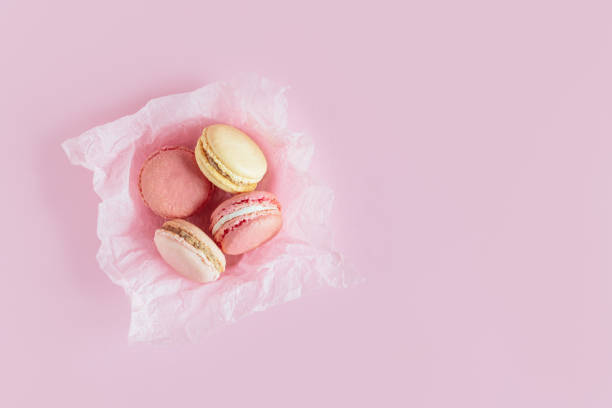 istock Tasty french macaroons on a pink pastel background. 1365189097