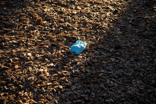 istock Coronavirus plastic waste environmental pollution. Disposable dirty face mask on ground, single use plastic trash on grass. How to dispose used medical masks right after coronavirus pandemic. 1365189109