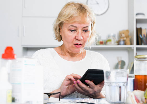 istock Mature woman with medicines and bills 1365189762