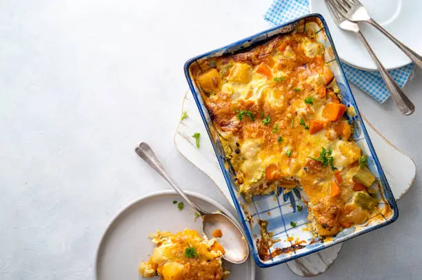 Vegetable gratin with sweet potato, celery, parsnip, carrot, cheese and eggs. Comfort, rustic one casserole foods