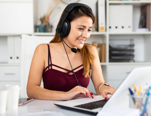 istock Young woman call centre operator with headphones in office 1365190335