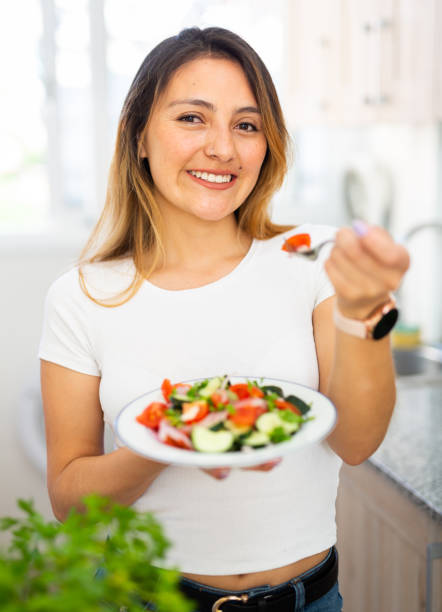 istock Female eating healthy salad with fresh vegetable 1365190417