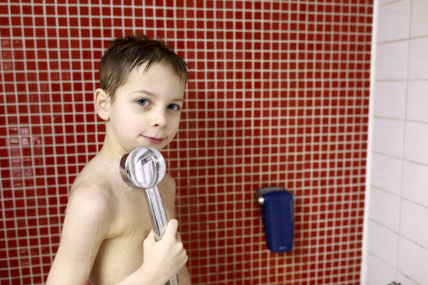 Portrait of child taking shower in bathroom