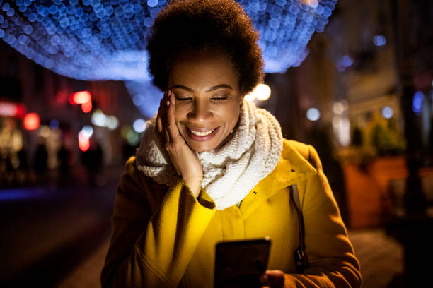 istock Young African American woman using smart phone and crying from happiness 1365191588