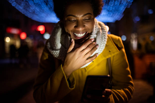 istock Young African American woman using smart phone smiling 1365191704