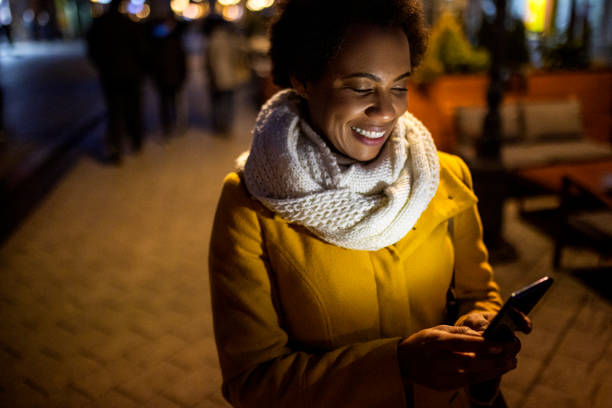 istock Smiling Young African American woman Text Messaging on the move 1365191711