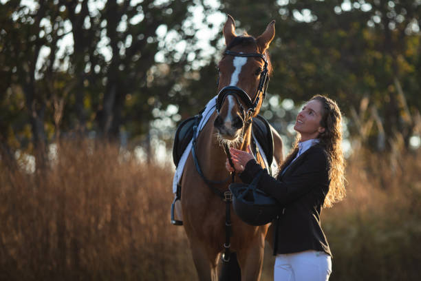 istock Young woman petting her horse 1365193386
