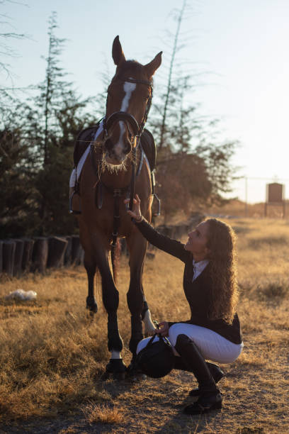 istock Young woman petting her horse 1365194328