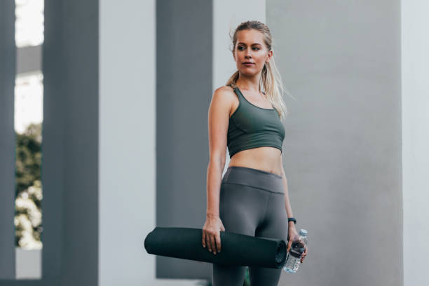 istock Fit Woman Standing Outdoors With an Exercise Mat, Staying Active Concept 1365195883