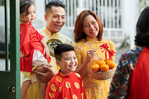 Happy mature couple and their children visiting grandparents for Lunar New Year celebration