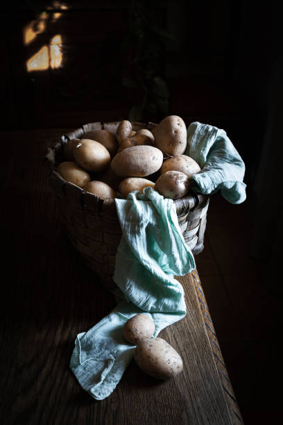 istock Potatoes from the garden in a basket on a rustic wooden kitchen table 1365201987