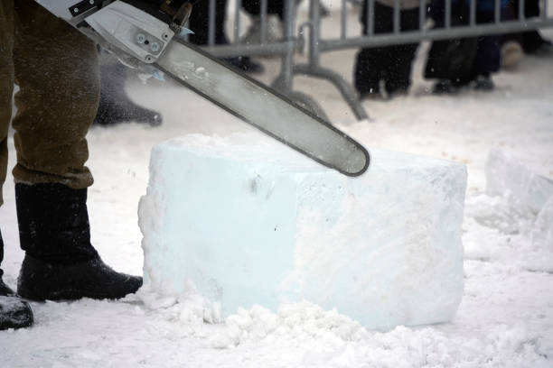 Saws an ice cube with an electric saw to decorate ice sculptures.