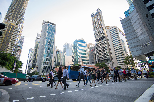 Singapore, Singapore - September 08, 2019: At the end of the working day
office workers walking on the streets of the Central Business District.