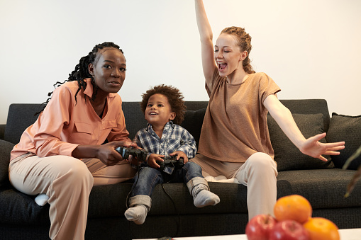 Excited mother celebrating her little son winning in videogame