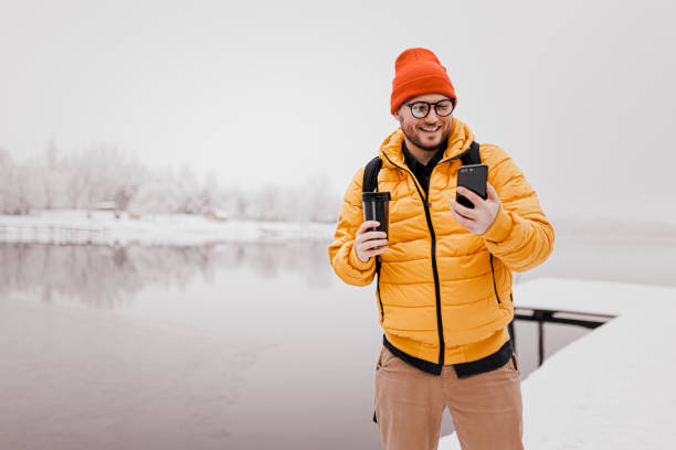 istock Man rests with hot coffee for a long walk through the snowy nature 1365209846
