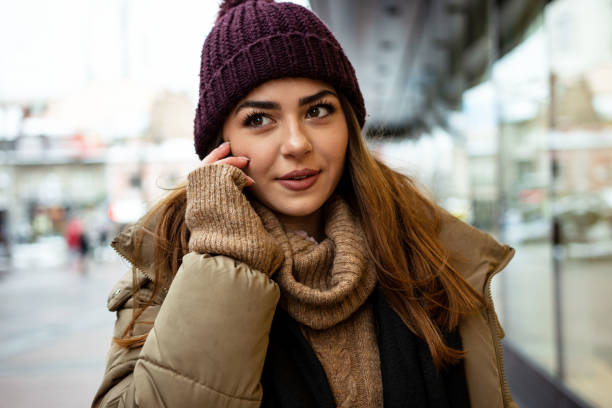istock Beautiful woman using mobile phone during shopping in wintertime 1365210729