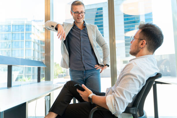 istock Two coworkers taking a break and having fun conversation in office 1365211105