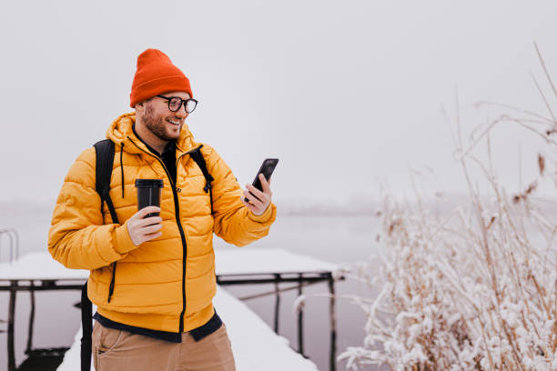 istock Man rests with hot coffee for a long walk through the snowy nature 1365211324