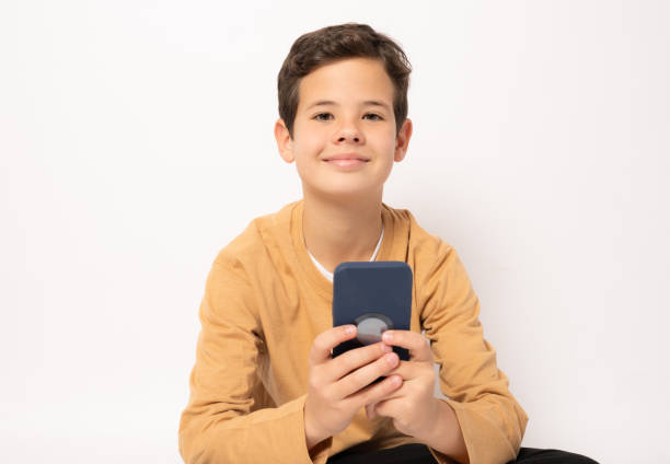 istock Caucasian boy in casual clothing using smartphone isolated over white background. 1365211904