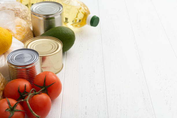 istock Various foodstuff on white wooden table. Food donation 1365214396