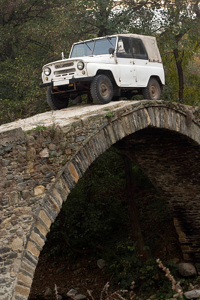 Old Russian off-road  car (UAZ) Old Russian off-road  car on a Roman bridge in Bulgaria. uaz 4x4 land vehicle woods stock pictures, royalty-free photos & images