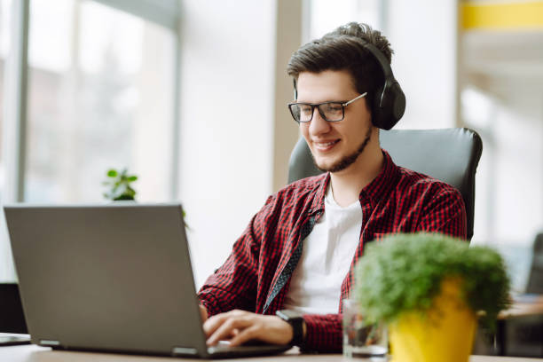 istock Education and working online. Young man with glasses working on laptop. Technology, 1365216666