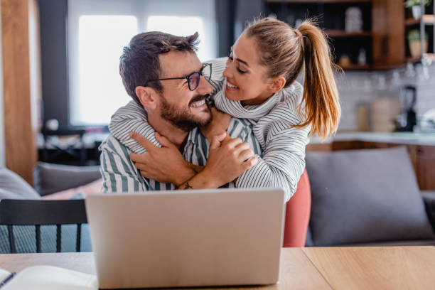 istock Happy couple using laptop at home 1365216813