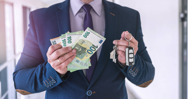happy business man bought an apartment and a car and holds the keys happy business man bought an apartment and a car and holds the keys. finance concept cash for cars stock pictures, royalty-free photos & images