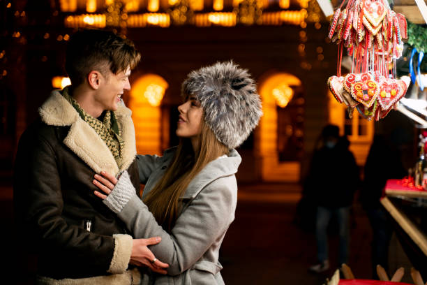 Young couple in the city at night in winter clothes being affectionate