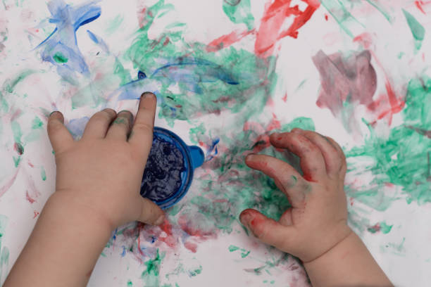 istock Child's hands draw with paints on paper close-up 1365219788