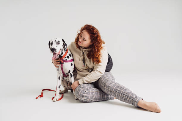 istock Woman posing with her dalmatian dog on white background 1365219789