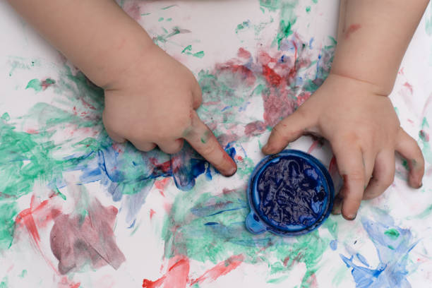 istock kid painting with paints with fingers, close-up, selective focus 1365219804