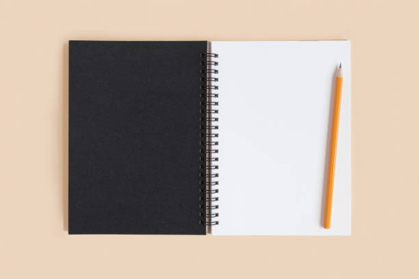istock Notebook with pencil. Open notebook on beige neutral color background, spiral notepad. Top view. Notepad with blank white and black pages for write, office flat lay. Copy Space 1365221852