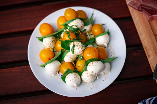 Tomato, Basil and Mozzarella skewers on a picnic table