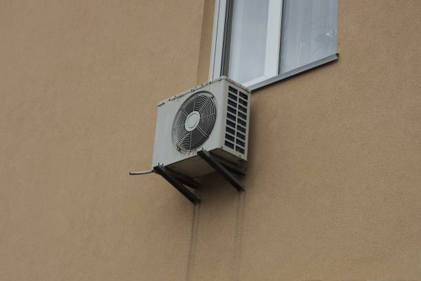 istock one gray air conditioner hangs on a brown concrete wall 1365223089