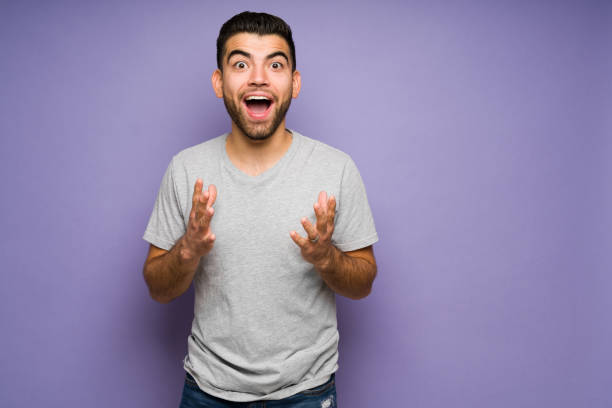 hombre emocionado al escuchar noticias maravillosas - eufórico fotografías e imágenes de stock