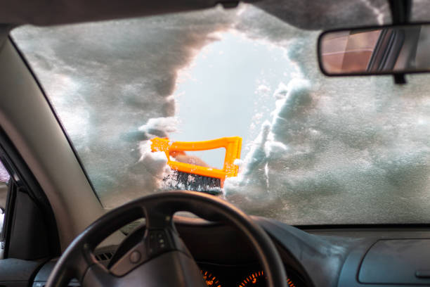 mężczyzna czyszczący przednią szybę samochodu skrobakiem ze śniegu i lodu - snow car window ice scraper zdjęcia i obrazy z banku zdjęć
