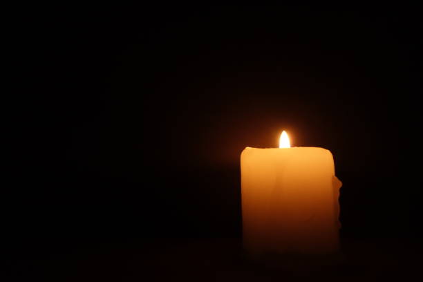 istock Candle burning on black background. Memory, mourning, remembrance day 1365226040